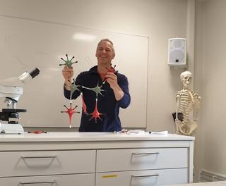 Pål Kvello holding a network of physical neurons